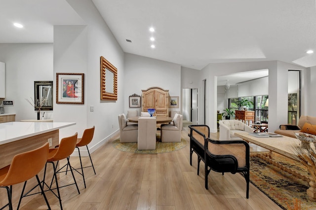 dining area featuring lofted ceiling and light hardwood / wood-style flooring