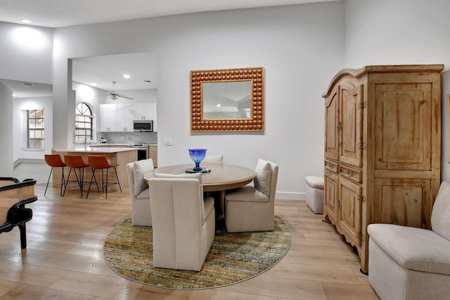 dining space with ceiling fan and light hardwood / wood-style floors