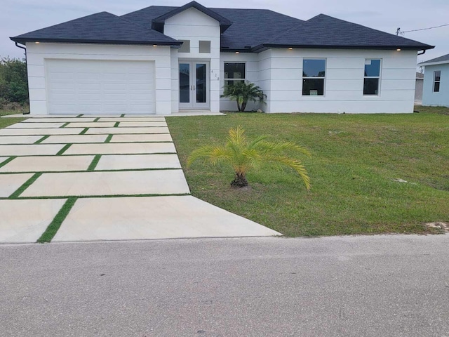 view of front of home with a garage, a front yard, and french doors