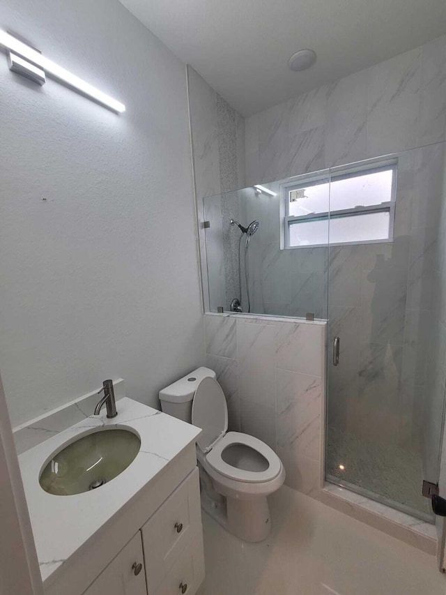 bathroom featuring vanity, toilet, and an enclosed shower