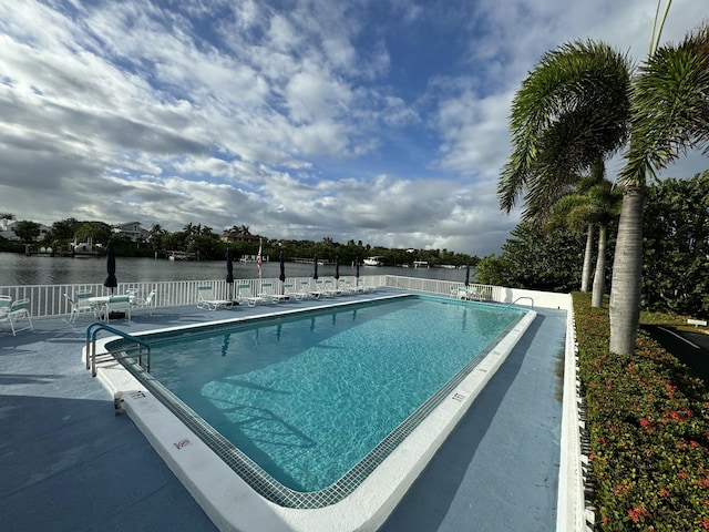 view of swimming pool featuring a patio and a water view