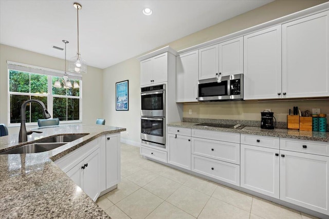 kitchen with white cabinets, decorative light fixtures, stainless steel appliances, sink, and light stone counters