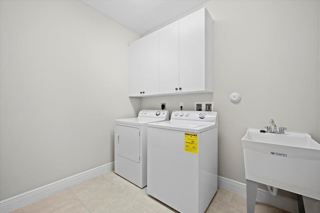 laundry area with sink, independent washer and dryer, and cabinets