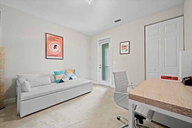 carpeted office featuring a textured ceiling