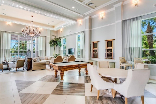 playroom with a towering ceiling, light tile patterned flooring, pool table, a notable chandelier, and ornamental molding