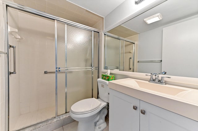 bathroom with vanity, tile patterned flooring, a shower with shower door, and toilet