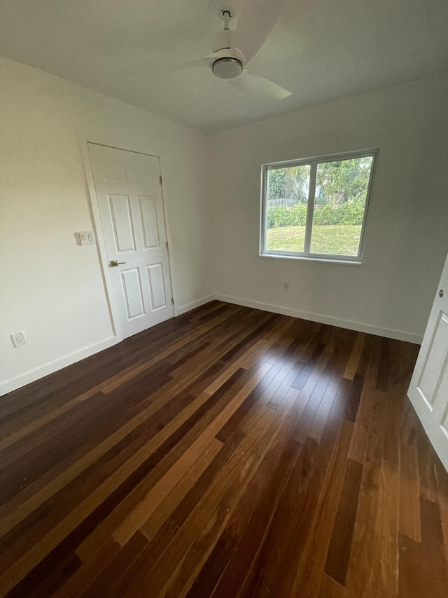 spare room with ceiling fan and dark wood-type flooring