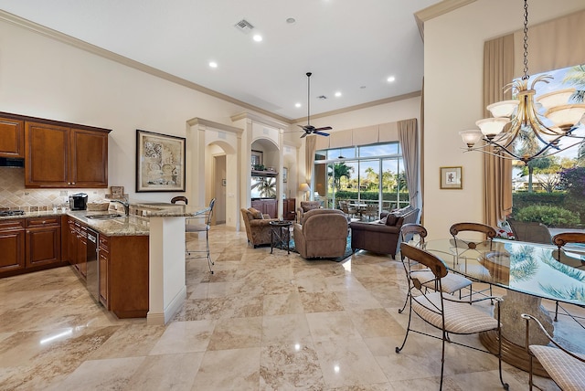 kitchen featuring a kitchen bar, kitchen peninsula, hanging light fixtures, and light stone countertops