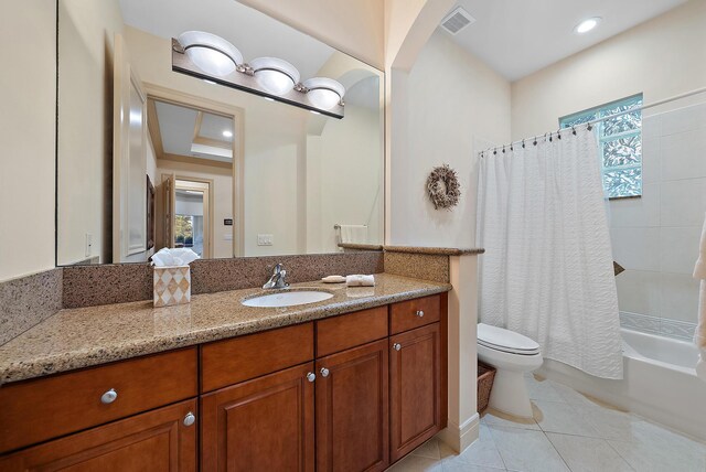 bedroom featuring ensuite bathroom, light carpet, ornamental molding, a tray ceiling, and ceiling fan