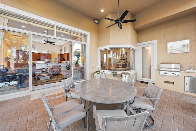 view of patio with ceiling fan, a grill, exterior kitchen, and sink