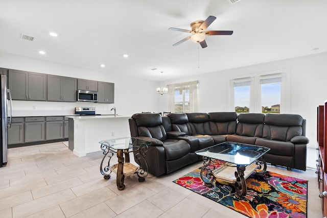 living room featuring sink, ceiling fan with notable chandelier, and light tile patterned flooring