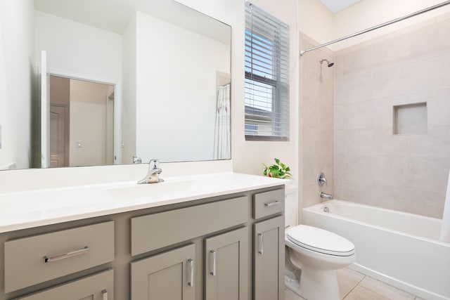 full bathroom featuring tile patterned floors, vanity, toilet, and tiled shower / bath combo