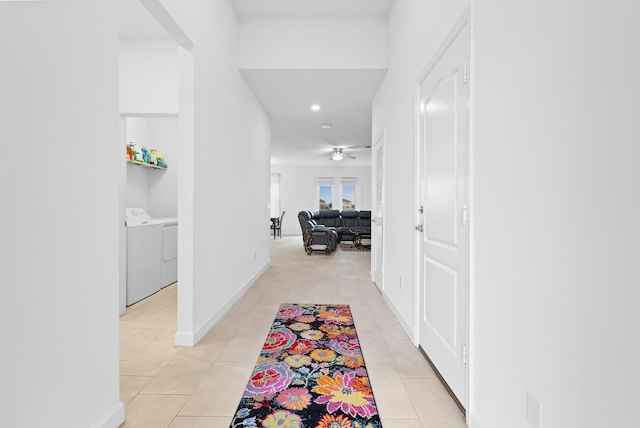 corridor featuring separate washer and dryer and light tile patterned floors