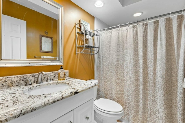 bathroom featuring vanity, toilet, and walk in shower