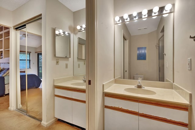 bathroom featuring ceiling fan, vanity, and toilet