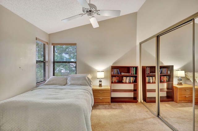 carpeted bedroom featuring vaulted ceiling, a textured ceiling, ceiling fan, and a closet