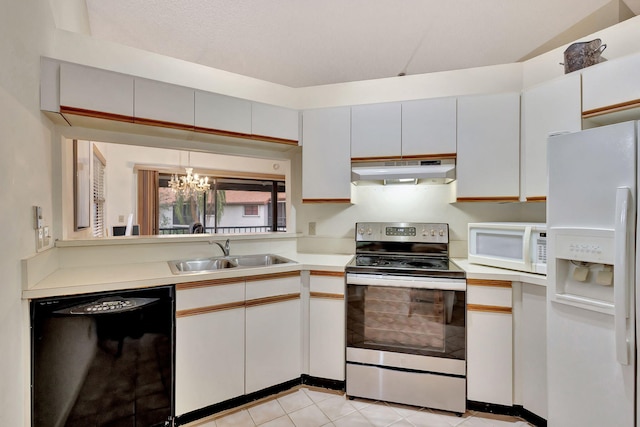 kitchen with sink, white appliances, light tile patterned floors, white cabinetry, and hanging light fixtures