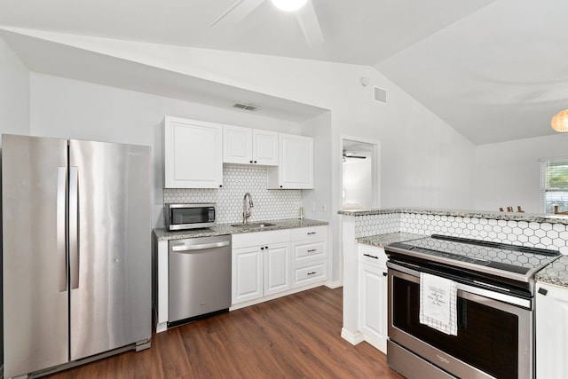 kitchen featuring lofted ceiling, dark wood-type flooring, white cabinetry, stainless steel appliances, and sink