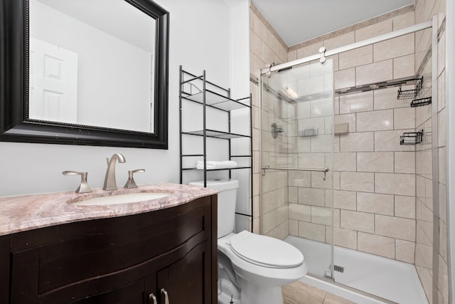 bathroom featuring vanity, toilet, walk in shower, and tile patterned floors