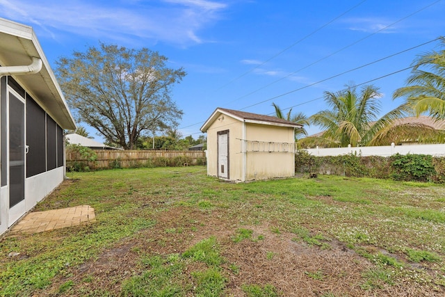 view of yard featuring a sunroom and a storage shed