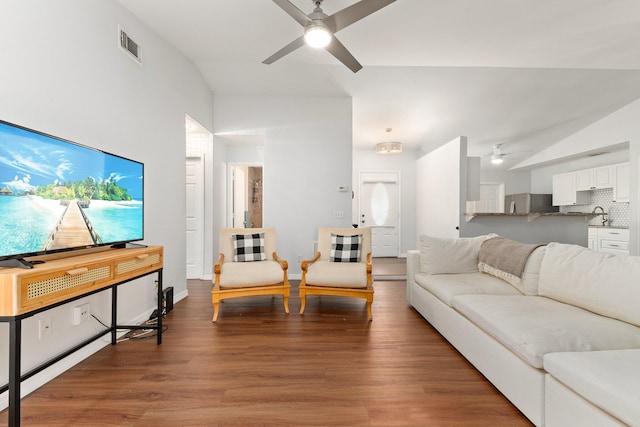 living room with wood-type flooring, lofted ceiling, sink, and ceiling fan