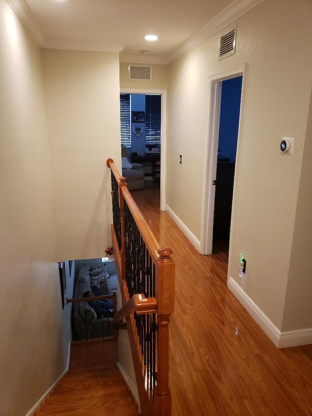 stairway featuring hardwood / wood-style floors and crown molding