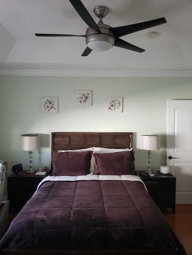 bedroom with crown molding, hardwood / wood-style floors, and ceiling fan