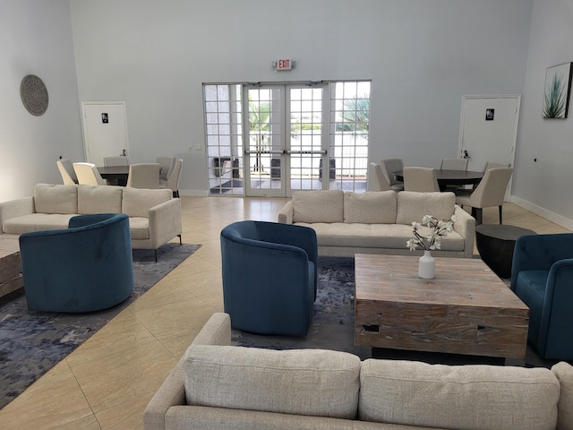 living room featuring tile patterned flooring, french doors, and a high ceiling