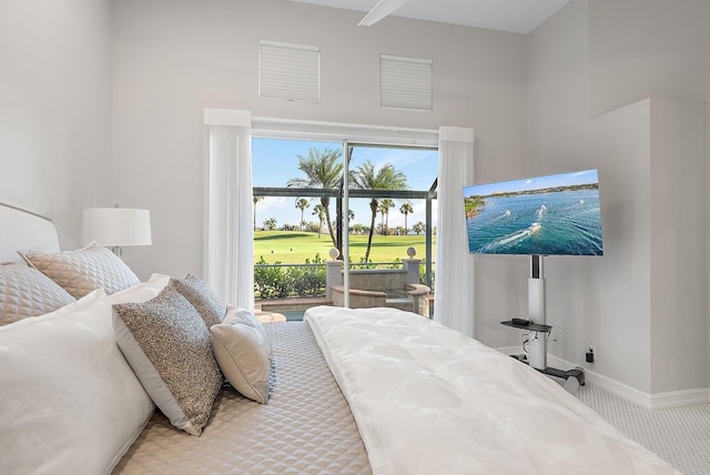 bedroom featuring access to outside, a high ceiling, and carpet