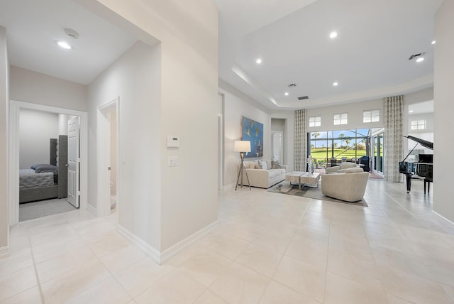 living room with a raised ceiling and light tile patterned flooring