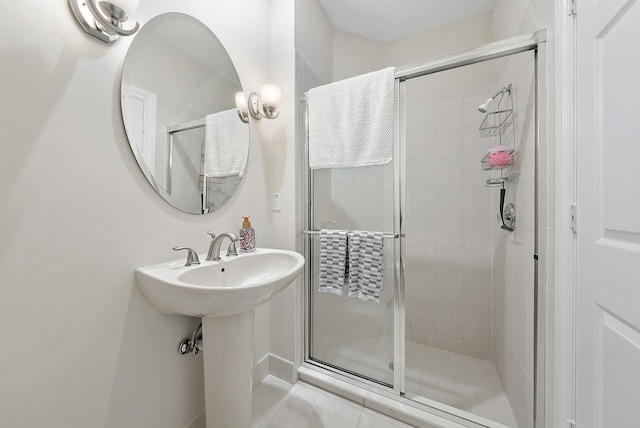 bathroom with a shower with door and sink