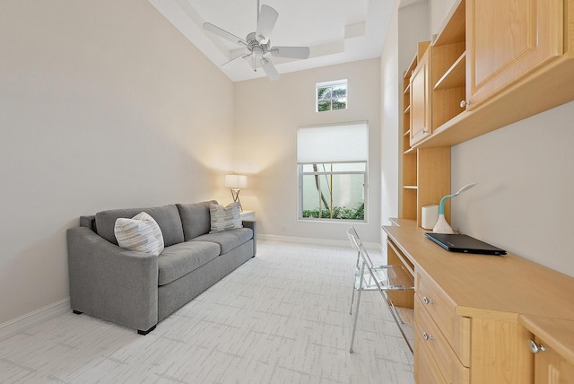 living room with a towering ceiling and ceiling fan