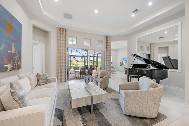 tiled living room featuring a towering ceiling and a raised ceiling