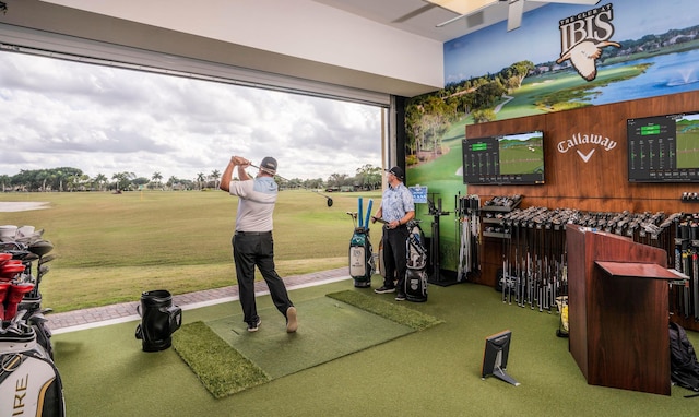 surrounding community with golf simulator and a yard