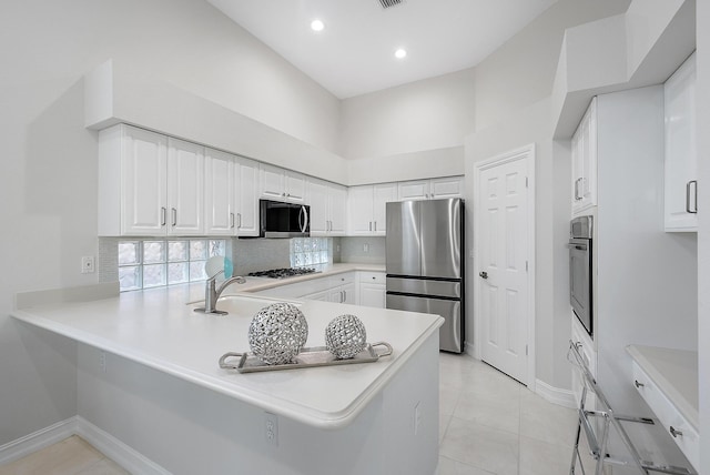 kitchen featuring sink, stainless steel appliances, kitchen peninsula, and white cabinets