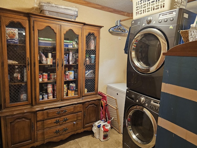 washroom featuring laundry area, light tile patterned floors, stacked washer / dryer, a textured wall, and a textured ceiling