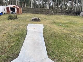 view of yard featuring fence and a fire pit