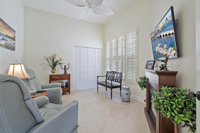 sitting room with ceiling fan, a high ceiling, and light tile patterned floors