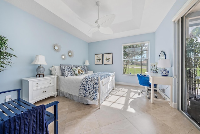 tiled bedroom with a raised ceiling and ceiling fan