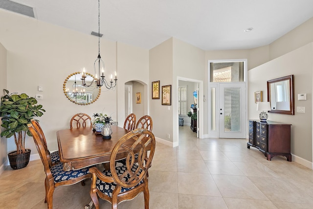 dining space featuring light tile patterned flooring and a chandelier