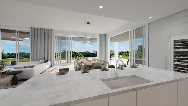 kitchen featuring sink, white cabinetry, and light stone countertops