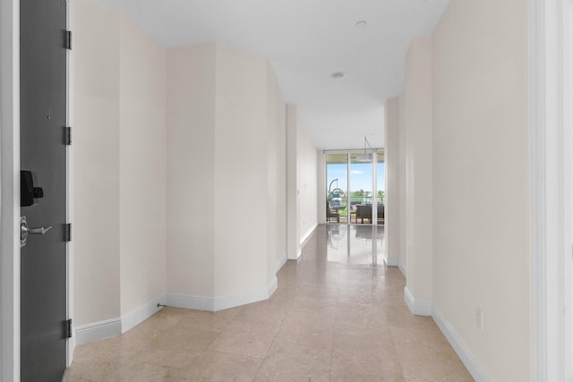 corridor featuring floor to ceiling windows and light tile patterned floors