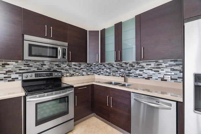 kitchen with tasteful backsplash, sink, light tile patterned floors, and stainless steel appliances