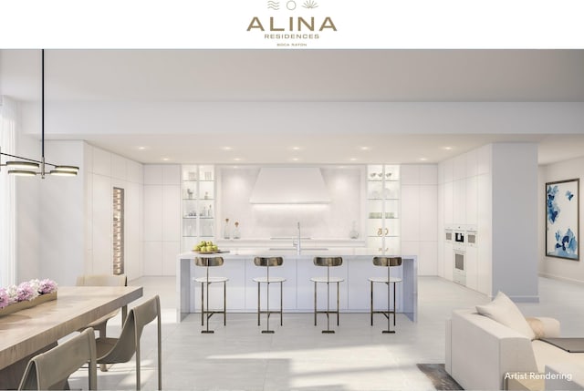 kitchen featuring white cabinets, hanging light fixtures, a kitchen bar, and sink