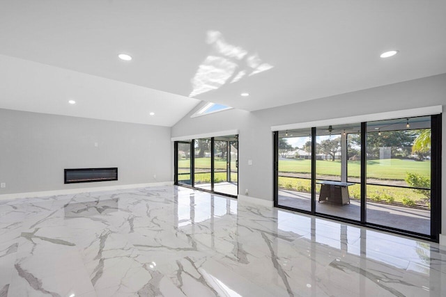 unfurnished living room with recessed lighting, marble finish floor, a glass covered fireplace, lofted ceiling, and baseboards