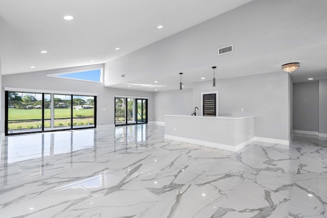 51 Woods Ln, Boynton Beach, FL 33436 - unfurnished living room featuring recessed lighting, a towering ceiling, light marble finish flooring, baseboards, and a sink