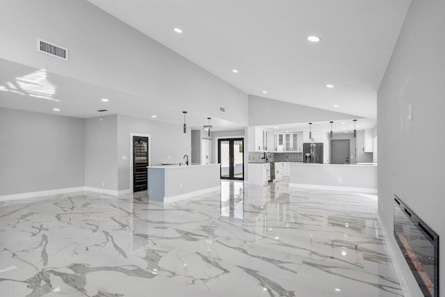 51 Woods Ln, Boynton Beach, FL 33436 - unfurnished living room with recessed lighting, baseboards, lofted ceiling, light marble finish flooring, and heating unit