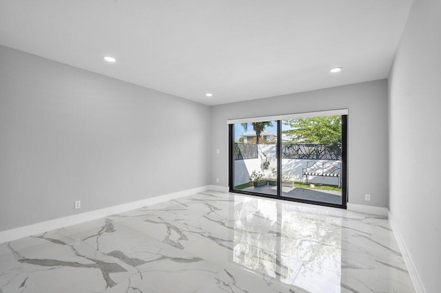 empty room featuring recessed lighting, baseboards, and marble finish floor