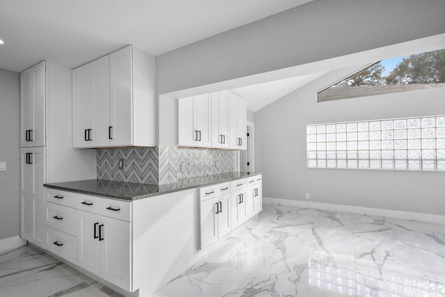 51 Woods Ln, Boynton Beach, FL 33436 - kitchen with baseboards, light marble finish flooring, dark stone counters, backsplash, and white cabinets