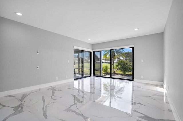 spare room with marble finish floor, baseboards, and recessed lighting